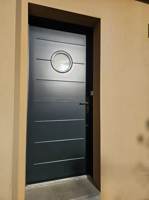 Peinture mais aussi rénovation ainsi que réparation de porte d'entrée autour de Rennes. Sur menuiserie aluminium, changement de couleur de peinture en gris anthracite RAL 7016.